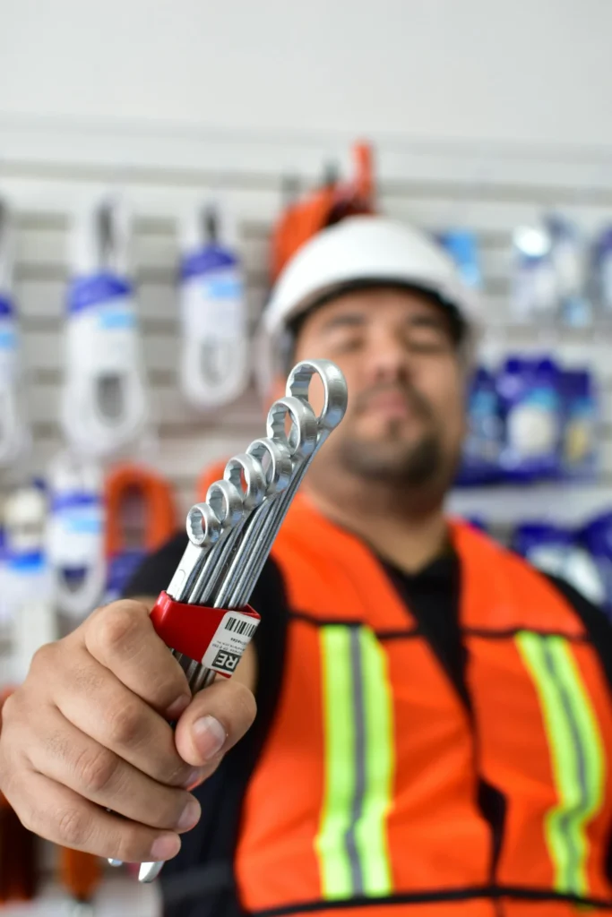 Bolting technician in PPE holding a set of wrenches